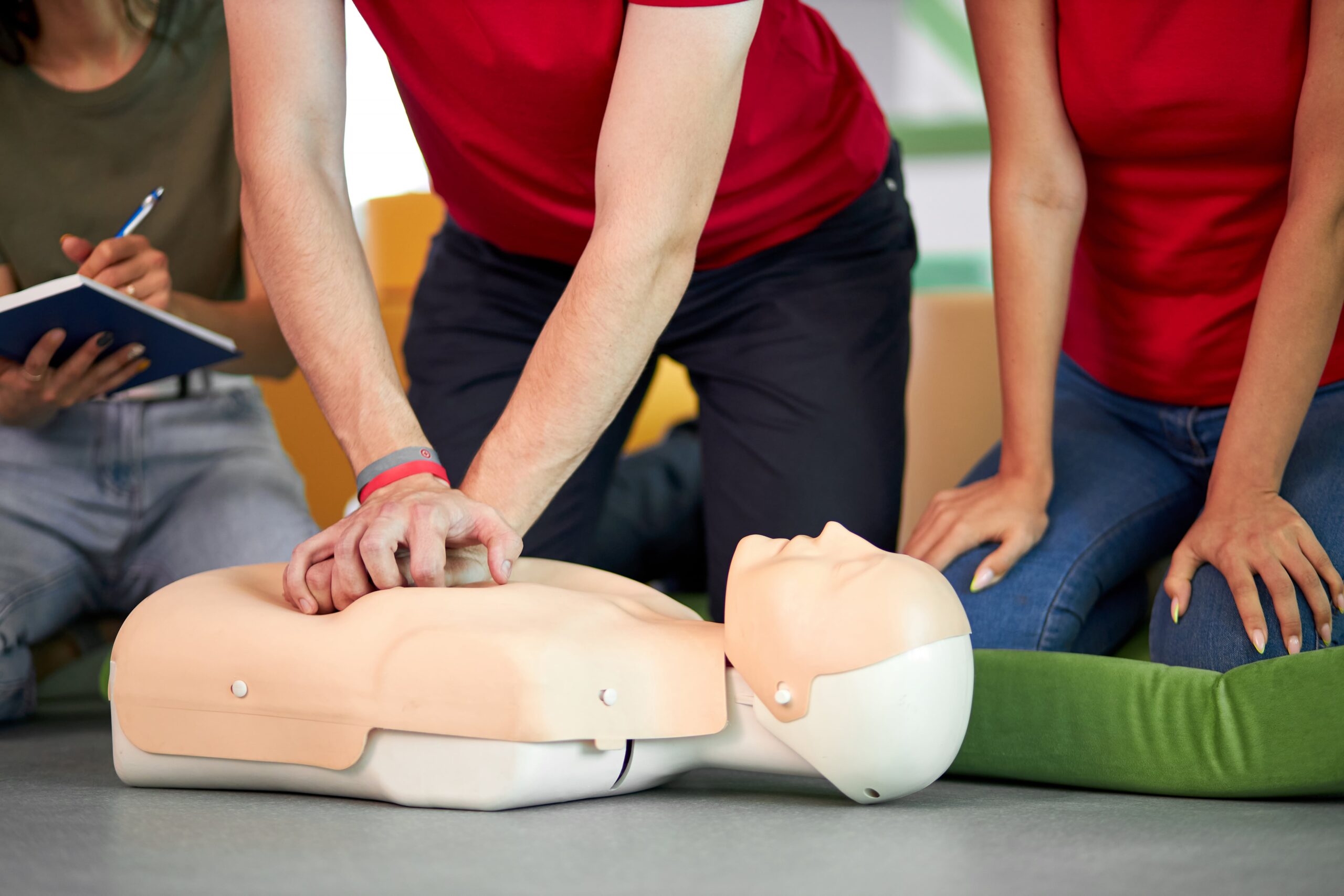 young-male-practicing-cpr-first-aid-on-mannequin-in-the-presence-of-people-min-1-scaled